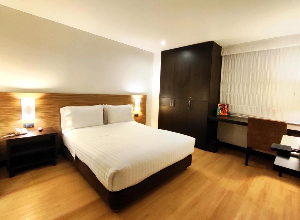 a bedroom with a large white bed and a desk at Scala 68 in Bogotá