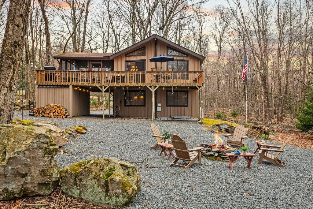 a cabin in the woods with chairs and a table at Atlas Point Lodge Sauna Fireplaces Kayaks Lakes Pet-Friendly Yard in Pocono Lake