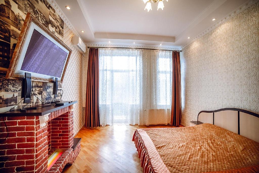 um quarto com uma cama e uma grande janela em Sudorak Apartments em Lviv