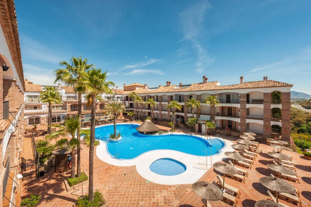 an overhead view of a hotel with a swimming pool and palm trees at La Cala Resort in La Cala de Mijas