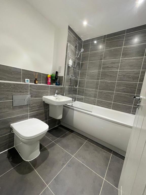 a bathroom with a toilet and a sink and a bath tub at County Side Maidstone in Maidstone