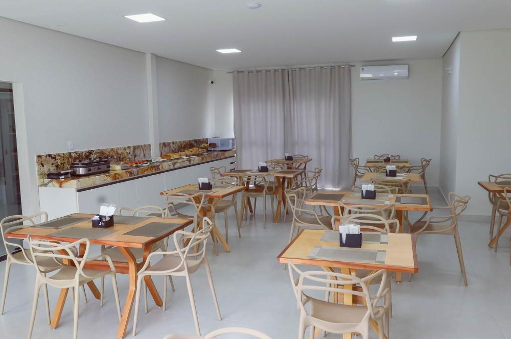een eetkamer met houten tafels en stoelen bij Novo Valle Hotel in Itinga