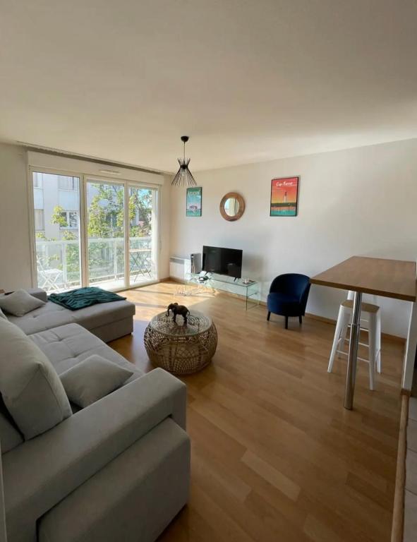 un salon avec un canapé et une table dans l'établissement Cocon lumineux, à Vichy