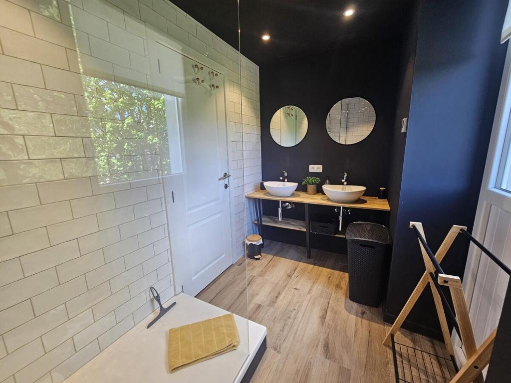 a bathroom with two sinks and two mirrors at Luxury Gites Les Balaux in Sainte-Marie