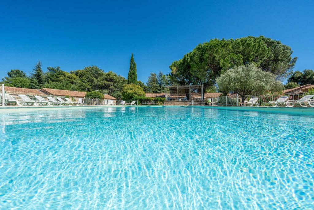 une grande piscine avec de l'eau bleue dans l'établissement Stone mas in residence with pool, à La Roque-sur-Pernes