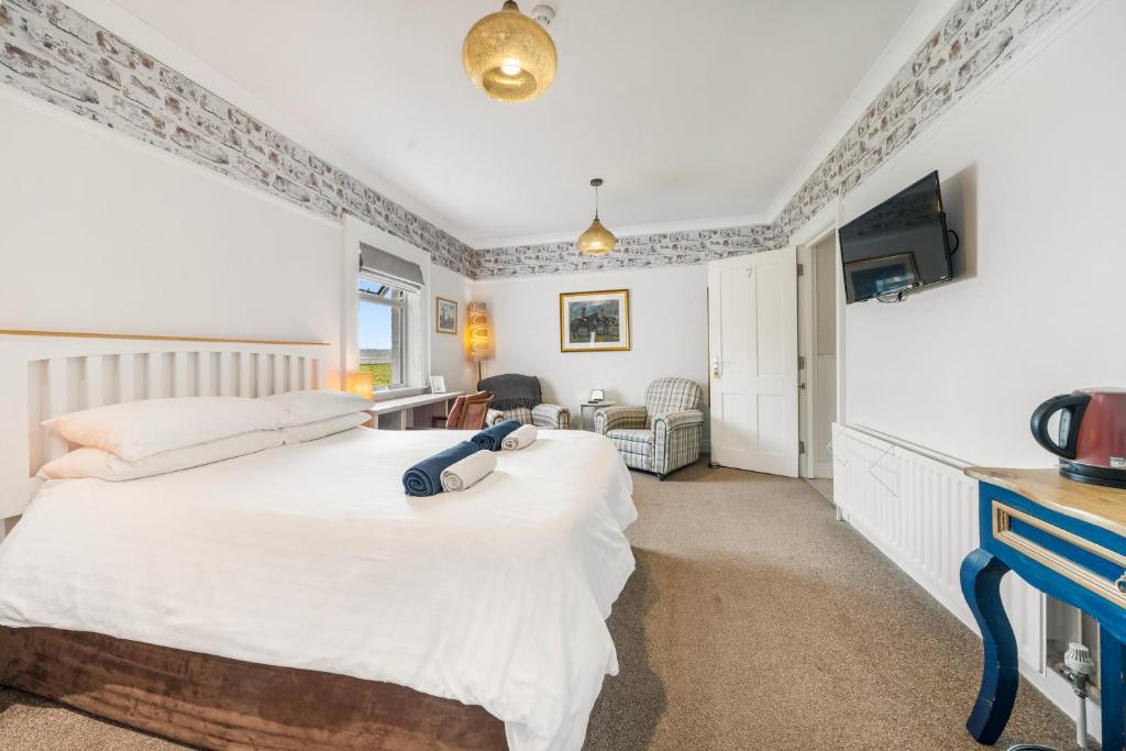 a bedroom with a white bed and a tv at Anvershiel House in Portrush