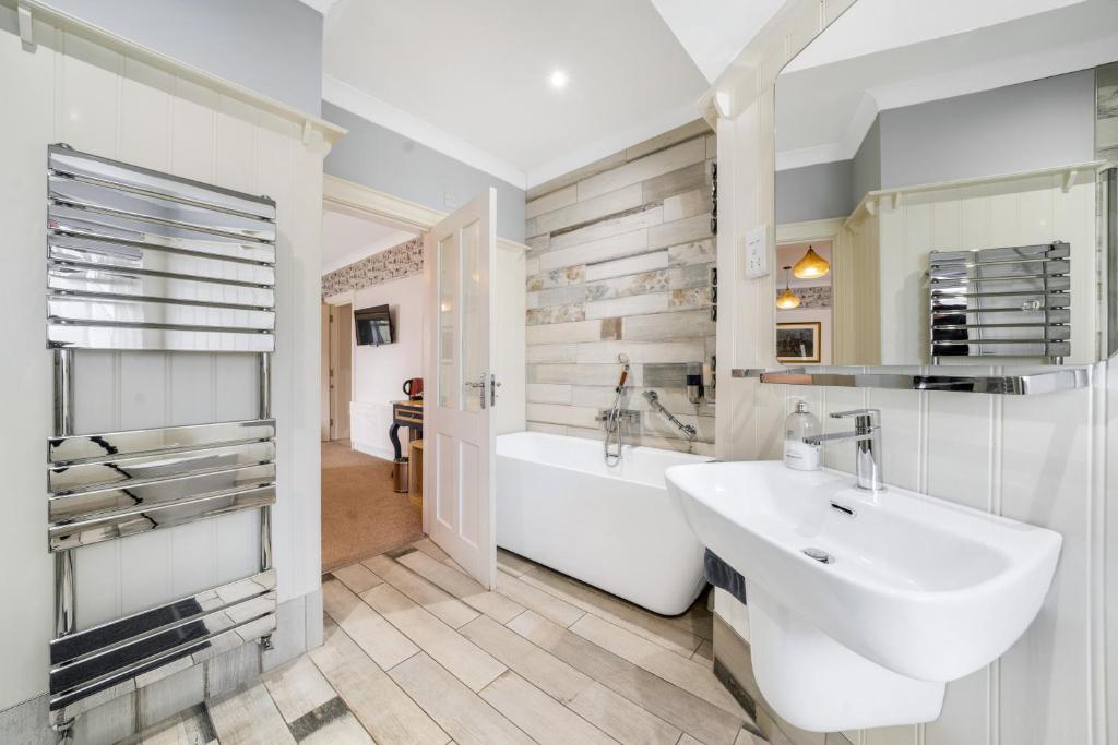 a bathroom with a sink and a tub and a bath tub at Anvershiel House in Portrush