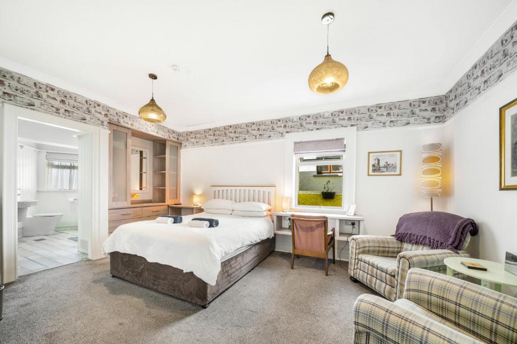 a bedroom with a bed and a desk and a couch at Anvershiel House in Portrush