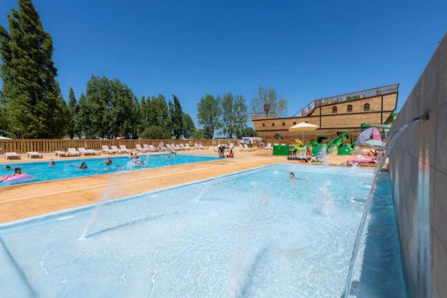 Una gran piscina con gente en el agua. en Mobil-home 6 personnes, en La Tranche-sur-Mer