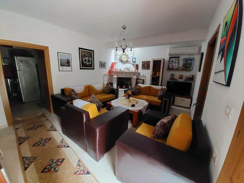 Una sala de estar con sofás y una mesa. en Ilia Gloria house, en Berat