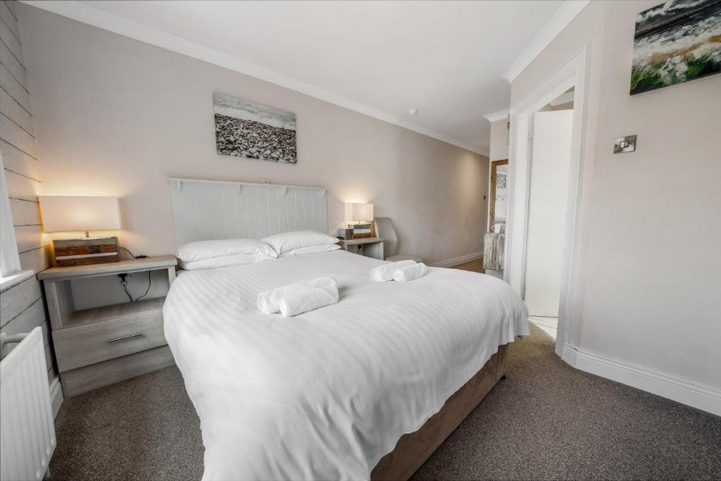 a bedroom with a large white bed with two pillows at Anvershiel House in Portrush