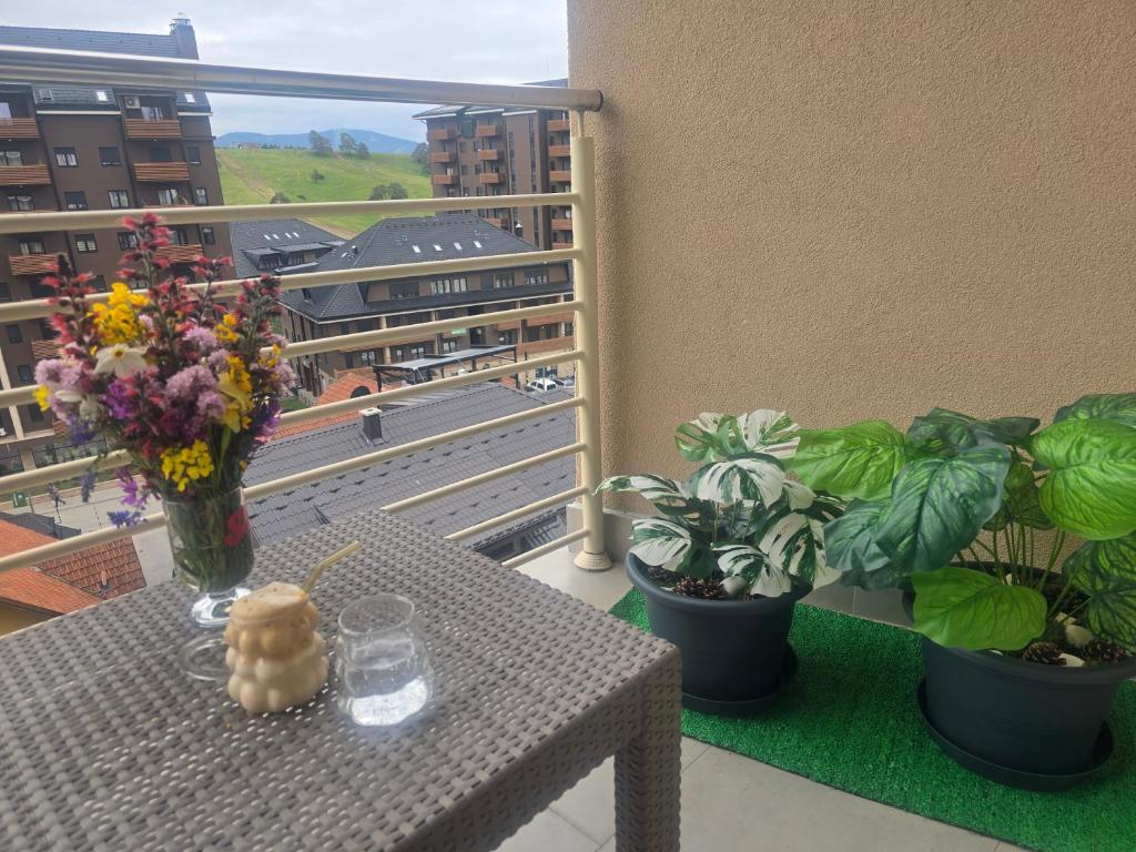 a table with flowers and plants on a balcony at Sunny view in Zlatibor