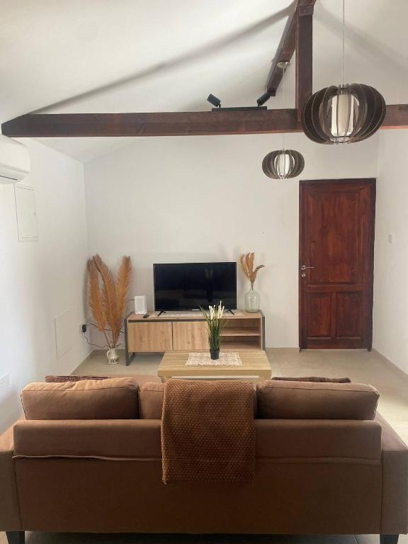 a living room with a couch and a table at Monolithos Cottage in Pachna
