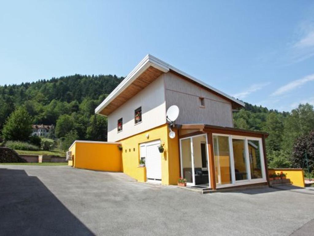 un edificio giallo e bianco con garage di Gîte familial aux Vosges avec jeux pour enfants, à proximité de la nature et activités sportives - FR-1-589-111 a Le Ménil