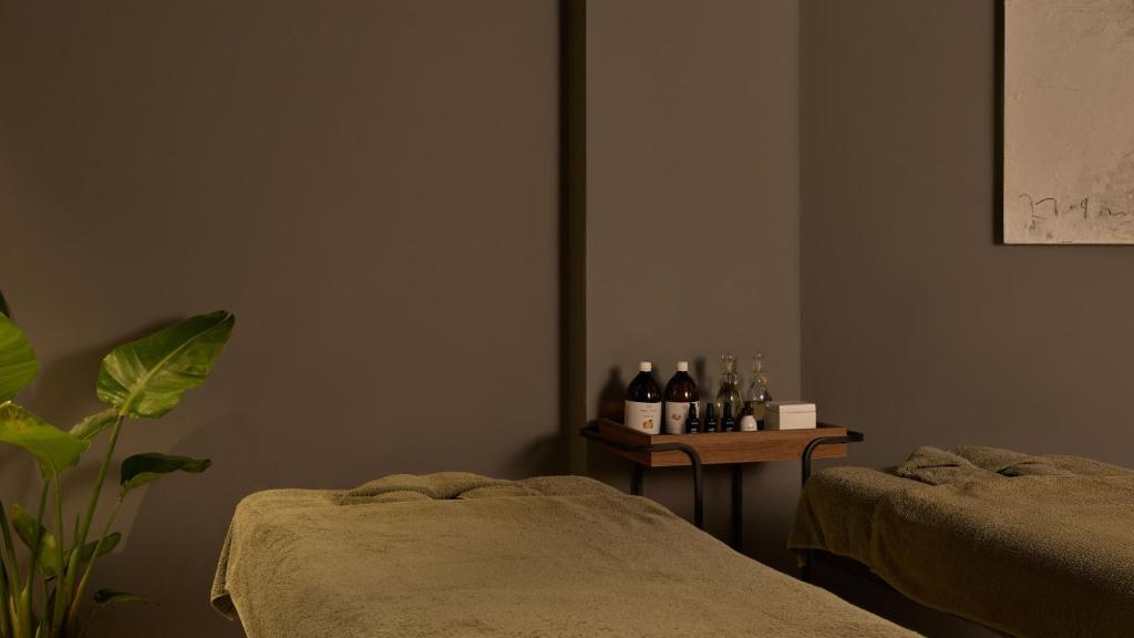 a room with two beds and a table with bottles of wine at Hotel Indigo Albufeira by IHG in Albufeira
