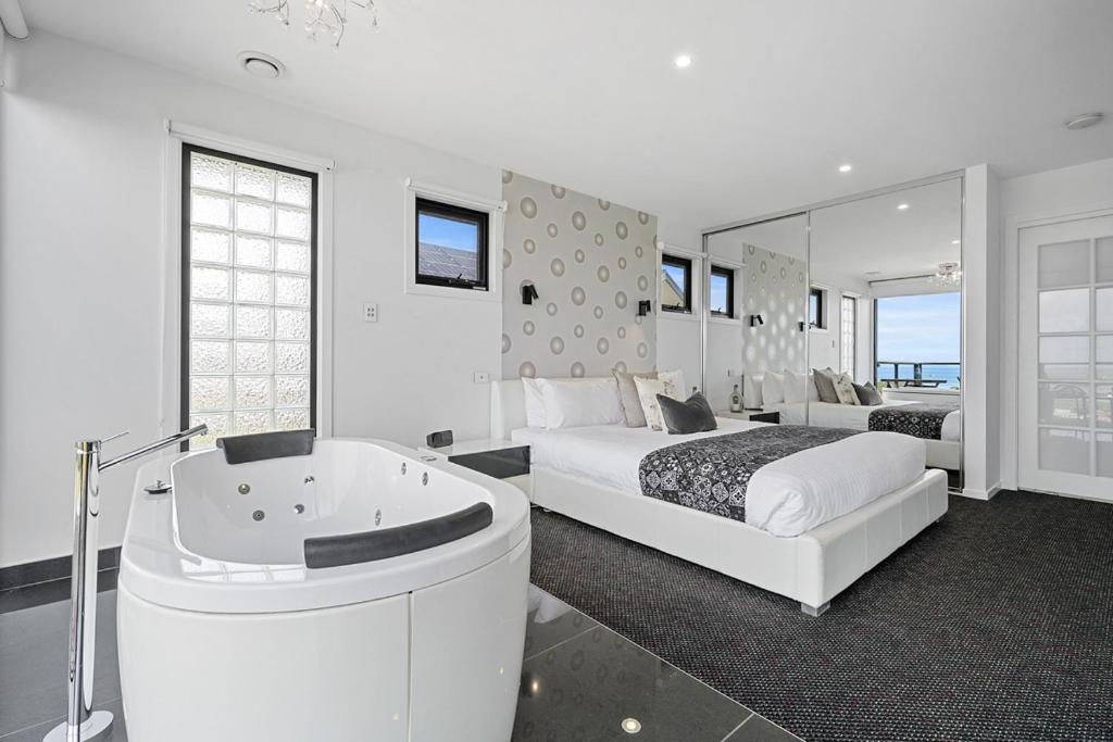 a bedroom with a bed and a bathtub and a bed and a bed at Horizon Deluxe Apartments in Stanley