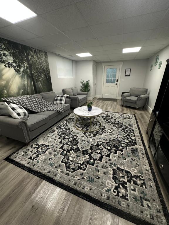 a living room with a couch and a table on a rug at Adventure Basement Unit in Buford