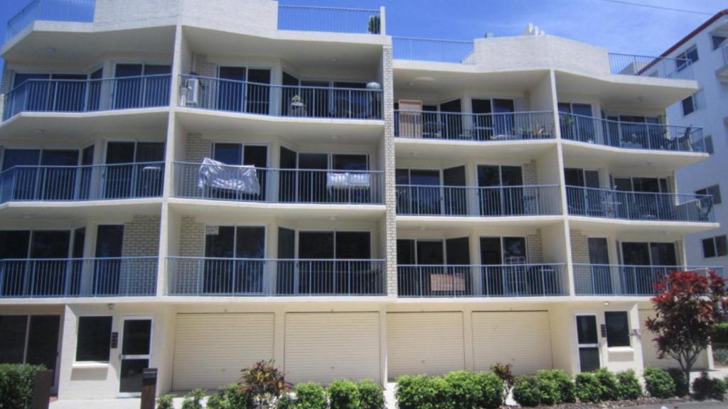 a large white apartment building with blue balconies at Windbourne Unit 8 in Golden Beach