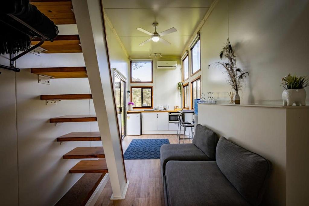un soggiorno con divano e cucina di Sithuri Tiny House by Tiny Away a Windeyer