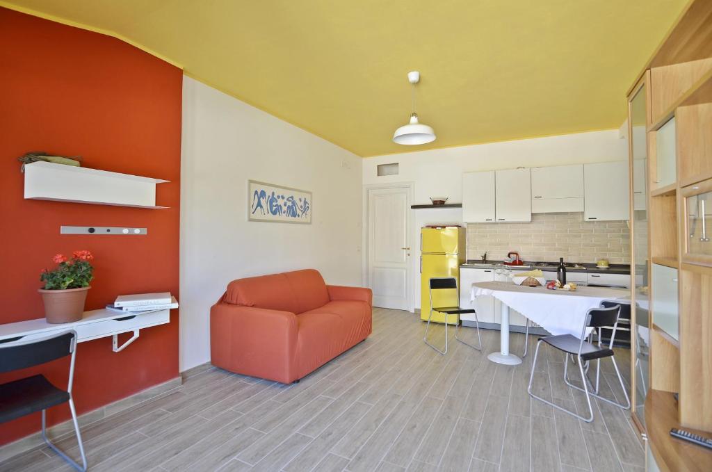 トルトリにあるCasa Vacanza Via Sulcisのリビングルーム(オレンジ色のソファ付)、キッチンが備わります。