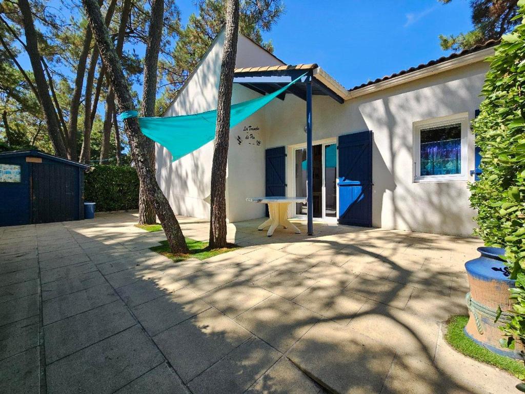 une maison avec un drapeau bleu accroché sur le côté dans l'établissement Charmante Maison avec Cour Privative - Proche Plage et Commerces, Animaux Acceptés sur Demande - FR-1-476-212, à La Tranche-sur-Mer