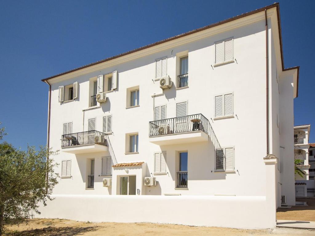 a white building with balconies on the side at Apartment in Orosei near Marina di Orosei Beach in Orosei