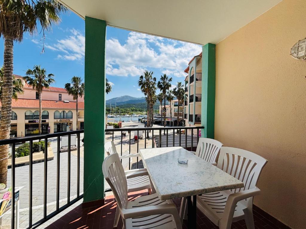 d'un balcon avec une table et des chaises et une vue sur l'eau. dans l'établissement Appartement 4 pers au port d'Argelès avec terrasse, parking - FR-1-309-512, à Argelès-sur-Mer