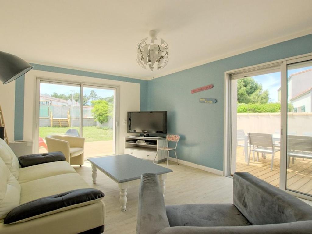 un salon avec un canapé et une télévision dans l'établissement Maison pour 6 avec jardin sud et parking à La Flotte - FR-1-835-21, à La Flotte