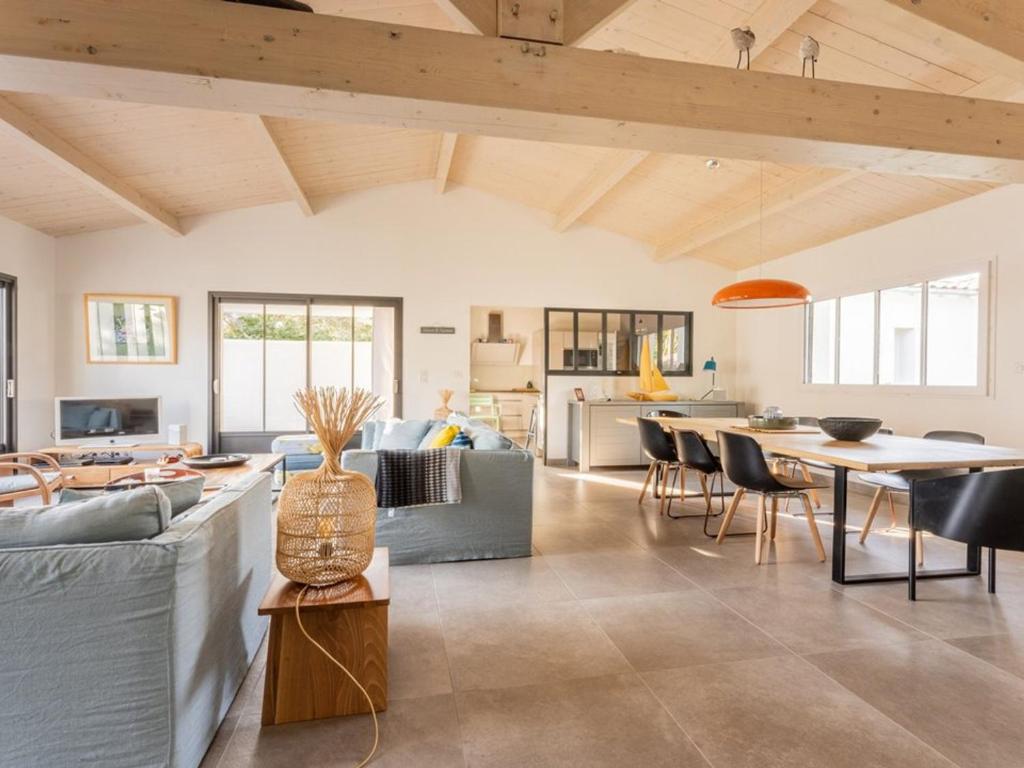 un salon avec un canapé et une table dans l'établissement Maison de plain-pied pour 8 pers. à La Flotte avec terrasse et parking - FR-1-835-15, à La Flotte