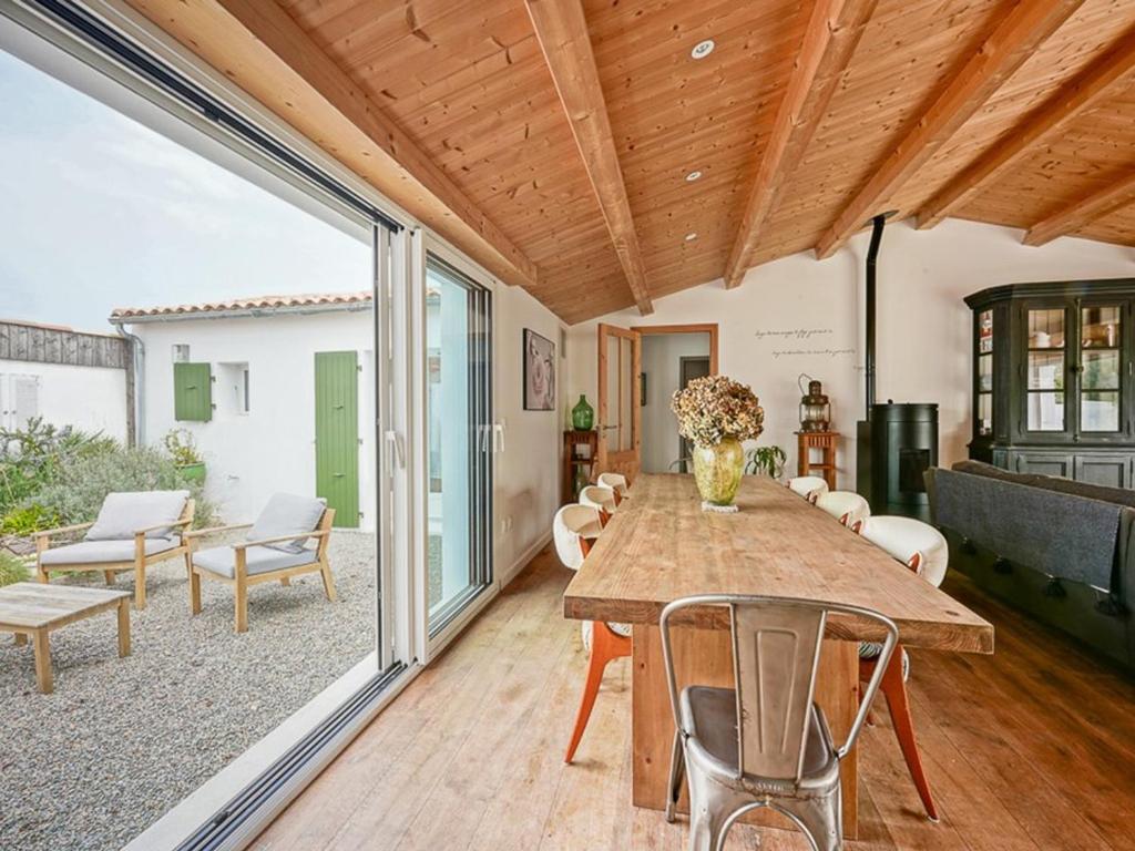 une salle à manger avec une table et une terrasse dans l'établissement Maison familiale avec piscine chauffée et terrasse à La Flotte - FR-1-835-20, à La Flotte