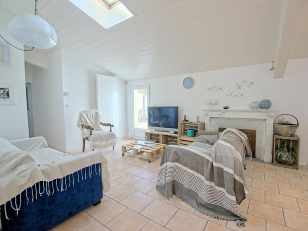 - un salon avec deux lits et une cheminée dans l'établissement Villa à St-Martin-de-Ré avec piscine chauffée pour 6 pers., 3 chambres - FR-1-835-24, à Saint-Martin-de-Ré