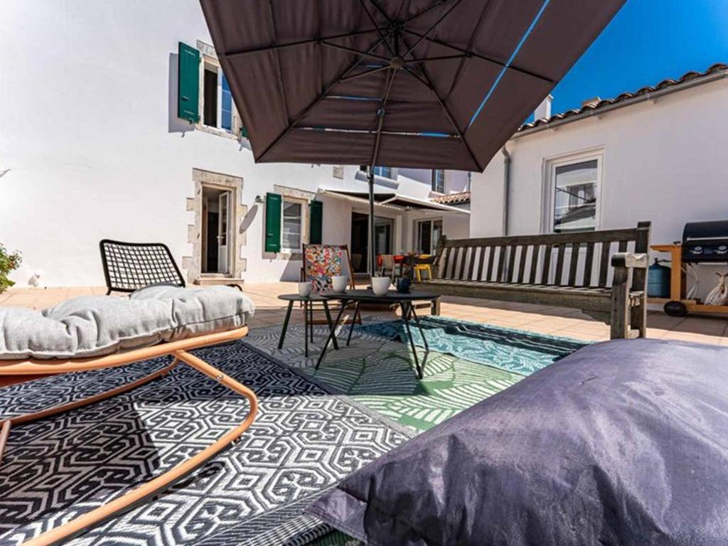 eine Terrasse mit einem Pool mit Sonnenschirm und Tisch in der Unterkunft Maison rénovée 2024, proche port et commerces, 3 chambres, parking - FR-1-835-10 in Rivedoux-Plage