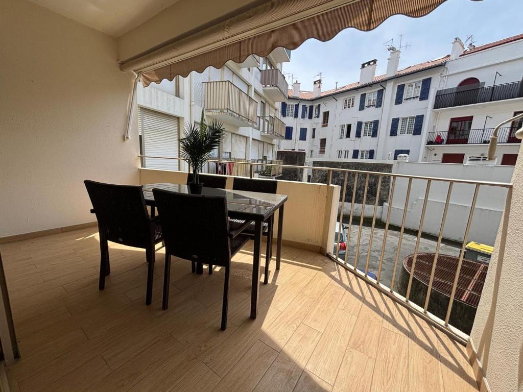 - un balcon avec une table et des chaises au-dessus d'un bâtiment dans l'établissement Studio lumineux à Hendaye, proche plage - FR-1-239-1124, à Hendaye