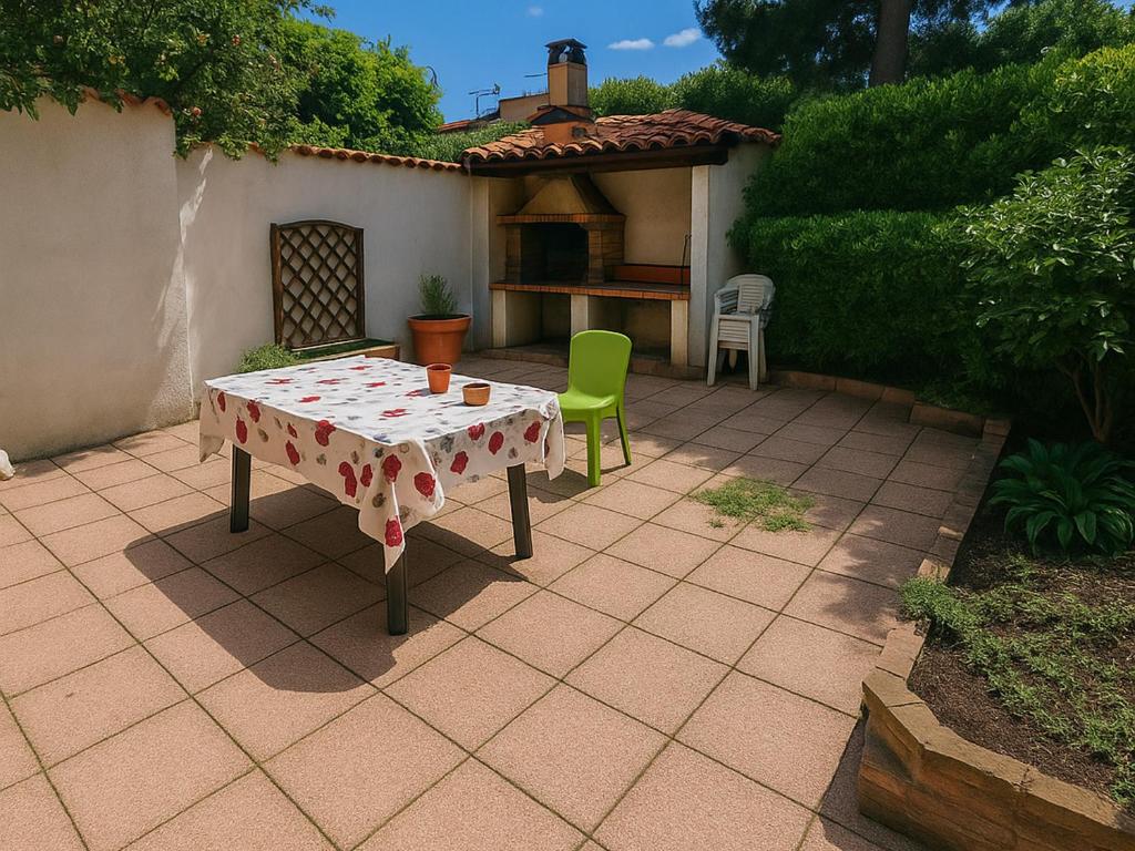 d'une terrasse avec une table et une chaise verte. dans l'établissement Maison 6 personnes à 150m de la plage avec terrasse - FR-1-732-107, à Argelès-sur-Mer
