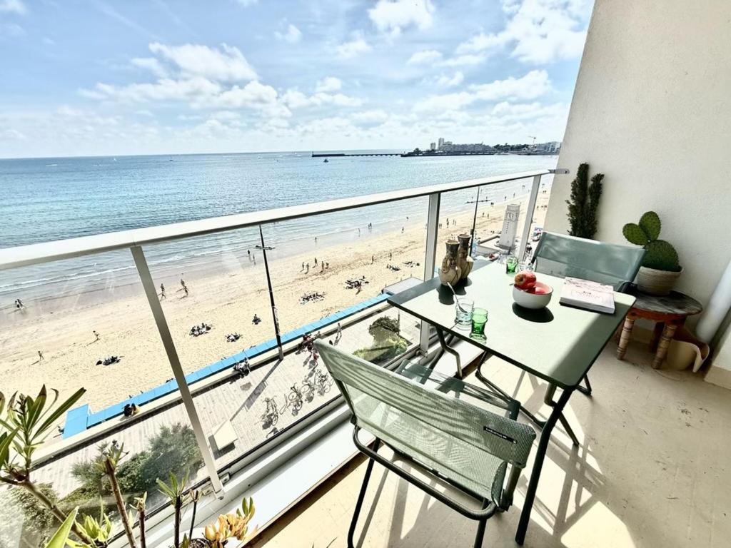 d'un balcon avec une table et une vue sur la plage. dans l'établissement Appartement T2 4 pers, 6ème étage avec WiFi, vue mer - FR-1-197-626, à Les Sables-dʼOlonne