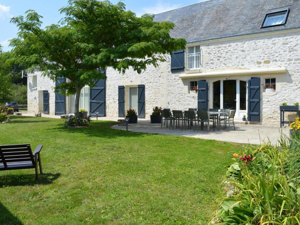 une maison en pierre avec un banc dans la cour dans l'établissement La Gitelière - FR-1-381-624, à Sainte-Catherine-de-Fierbois