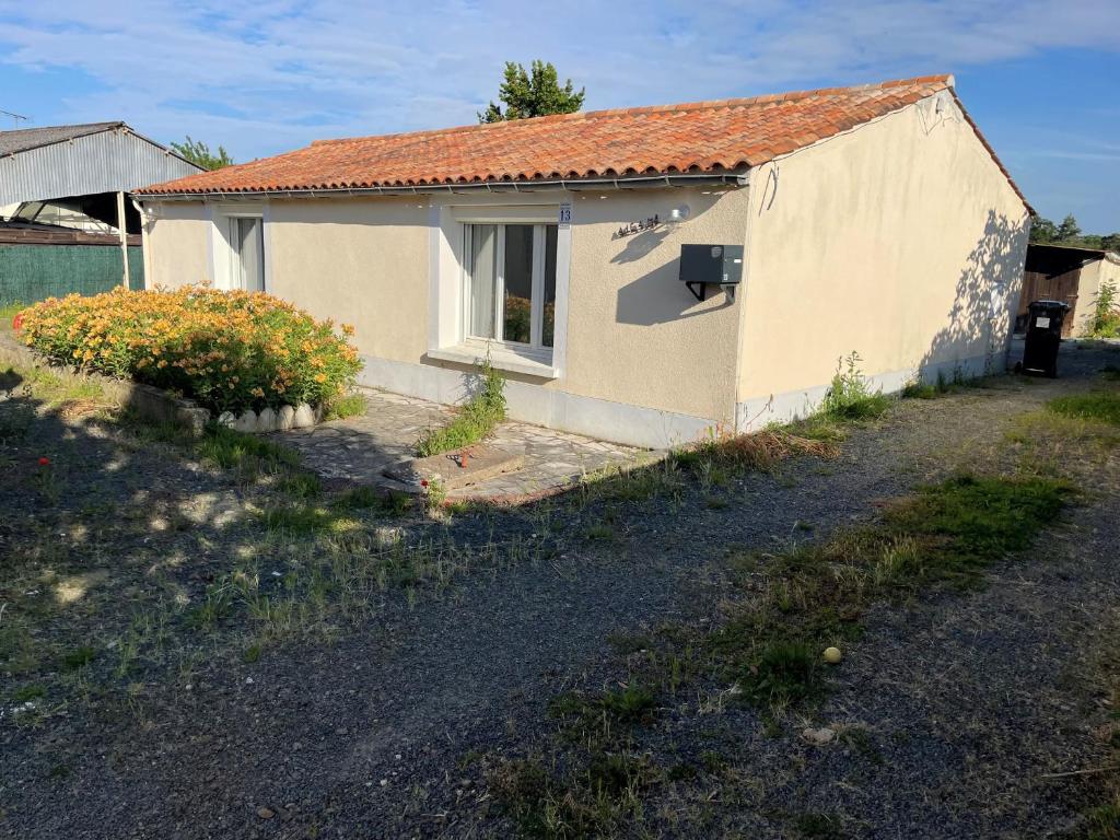 une petite maison avec une fenêtre dans une cour dans l'établissement Maison rénovée au calme, animaux admis, 5 personnes - FR-1-476-239, à Saint-Michel-en-lʼHerm