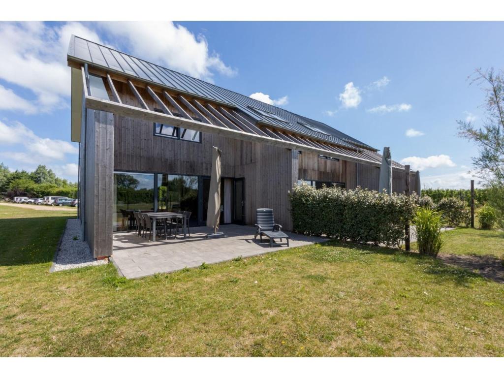 una casa con solárium en la parte superior de un patio en Holiday Home in Vrouwenpolder near Beach, en Vrouwenpolder