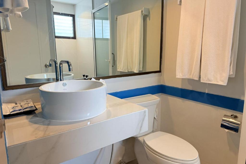 a white bathroom with a sink and a toilet at Days Inn by Wyndham Patong Beach in Patong Beach