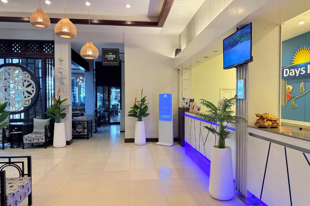 a lobby of a restaurant with potted plants at Days Inn by Wyndham Patong Beach in Patong Beach