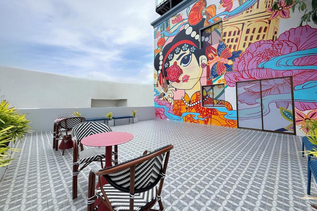 a mural on the side of a building with a table and chairs at Days Inn by Wyndham Patong Beach in Patong Beach