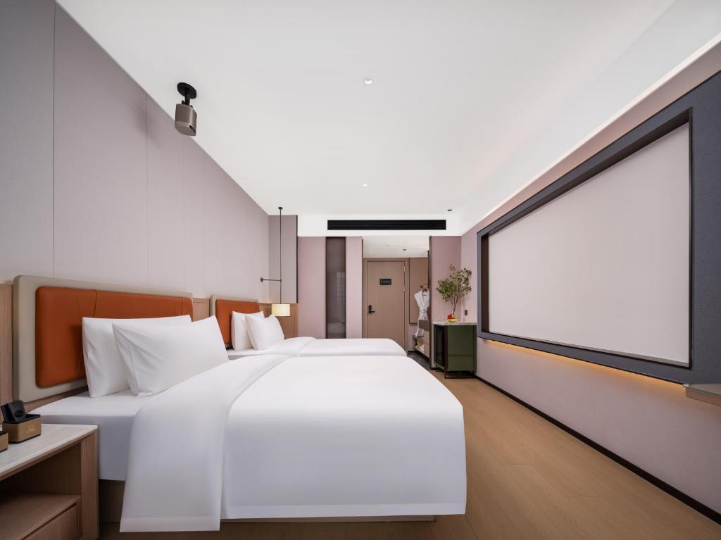 Postel nebo postele na pokoji v ubytování 义乌君忆云澜国际酒店 Yiwu Junyi Yunlan International Hotel