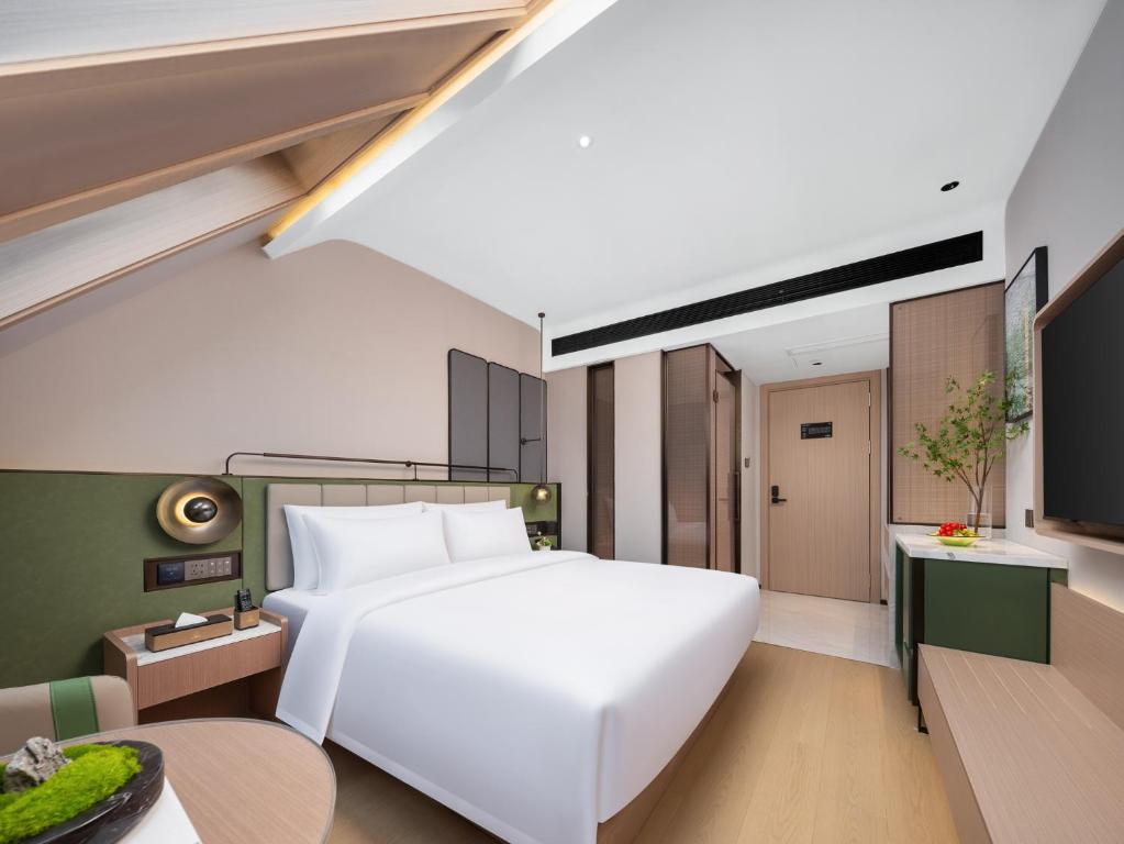 Postel nebo postele na pokoji v ubytování 义乌君忆云澜国际酒店 Yiwu Junyi Yunlan International Hotel