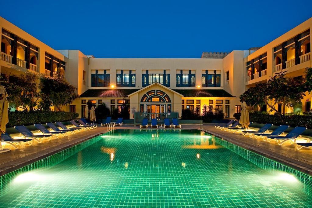 a swimming pool in front of a building at night at Diar Lemdina Hotel in Hammamet
