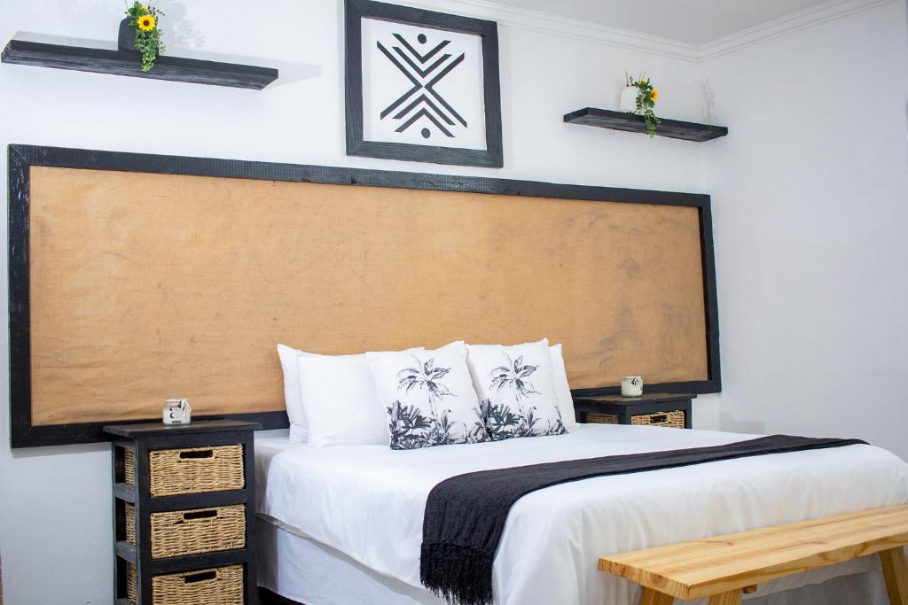 a bedroom with a bed with a wooden headboard at Kanana Villas - Maun Luxury One Bedroom Apartment in Maun