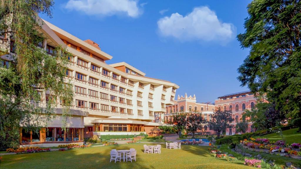 un grande edificio con tavoli e sedie in un parco di Hotel Yak & Yeti a Kathmandu