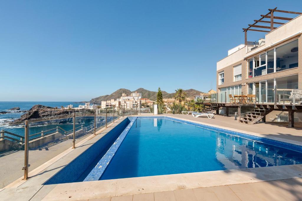 a swimming pool with the ocean in the background at Rocamar in Cabo de Palos