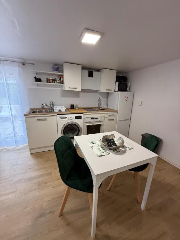 une petite cuisine avec une table et des chaises blanches dans l'établissement Studio with Garden, à Villerupt