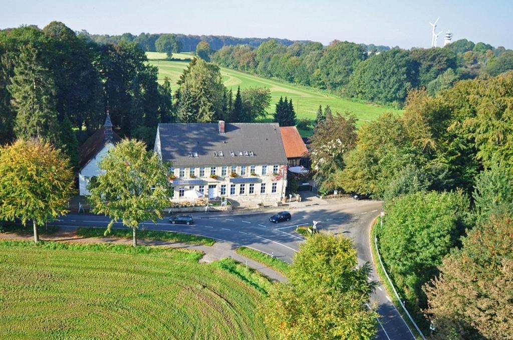 an aerial view of a house with a road and trees at Hotel Marienhof Baumberge in Nottuln