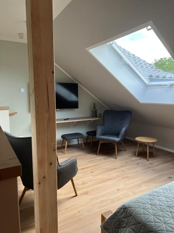 a attic room with a skylight and a bed and chairs at Lippischer-Traum 1 in Detmold
